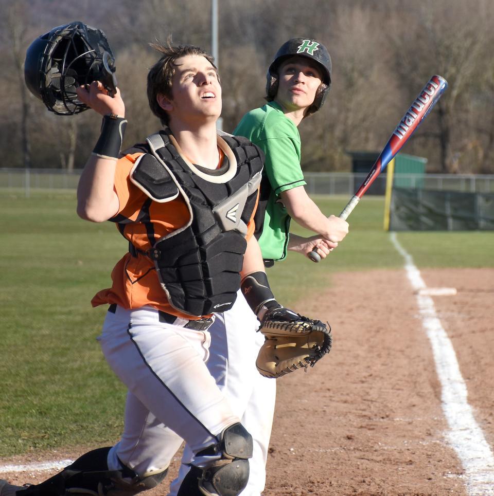 Cooperstown catcher Emerson Toulson and Herkimer Magician Lucas Malinowski (from left) track the path of Malinowski's foul pop fly Friday.