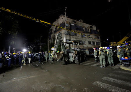 A soldier drives an excavator on a street as rescue teams search for students at the Enrique Rebsamen school after an earthquake in Mexico City, Mexico September 22, 2017. REUTERS/Daniel Becerril/Files