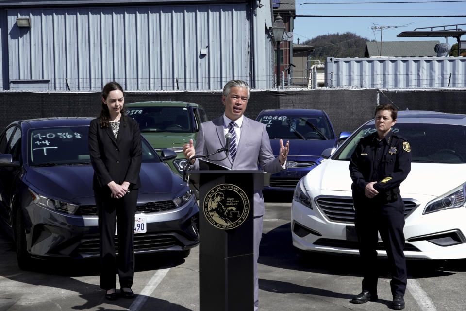 California Attorney General Rob Bonta, center, flanked by Deputy Attorney General Holly Mariella, left, and Berkeley Police Chief Jennifer Louis, right, speaks during a news conference Thursday, April 20, 2023, in Berkeley, Calif., about the surge in thefts of KIA and Hyundai vehicles. Attorneys general in 17 states plus Washington, DC, on Thursday urged the federal government to recall millions of Kia and Hyundai cars because they are too easy to steal; a response to a sharp increase in thefts fueled by a viral social media challenge. (AP Photo/Terry Chea)