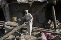 A man salvages belongings from his destroyed house after an earthquake in Gayan district in Paktika province, Afghanistan, Sunday, June 26, 2022. A powerful earthquake struck a rugged, mountainous region of eastern Afghanistan early Wednesday, flattening stone and mud-brick homes in the country's deadliest quake in two decades, the state-run news agency reported. (AP Photo/Ebrahim Nooroozi)