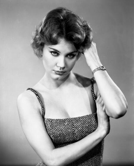 Elizabeth MacRae poses in spaghetti strap top, with her hand in her hair, in a black-and-white portrait
