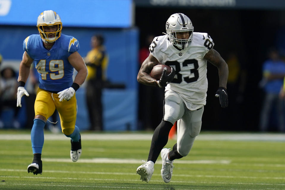 Las Vegas Raiders tight end Darren Waller (83) runs in front of Los Angeles Chargers linebacker Drue Tranquill (49) during the second half of an NFL football game in Inglewood, Calif., Sunday, Sept. 11, 2022. (AP Photo/Gregory Bull)