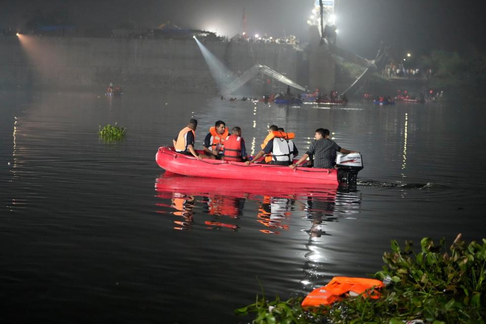 Rescuers on boats search in the Machchu river next to a cable bridge that collapsed in Morbi (Copyright 2022 The Associated Press. All rights reserved)