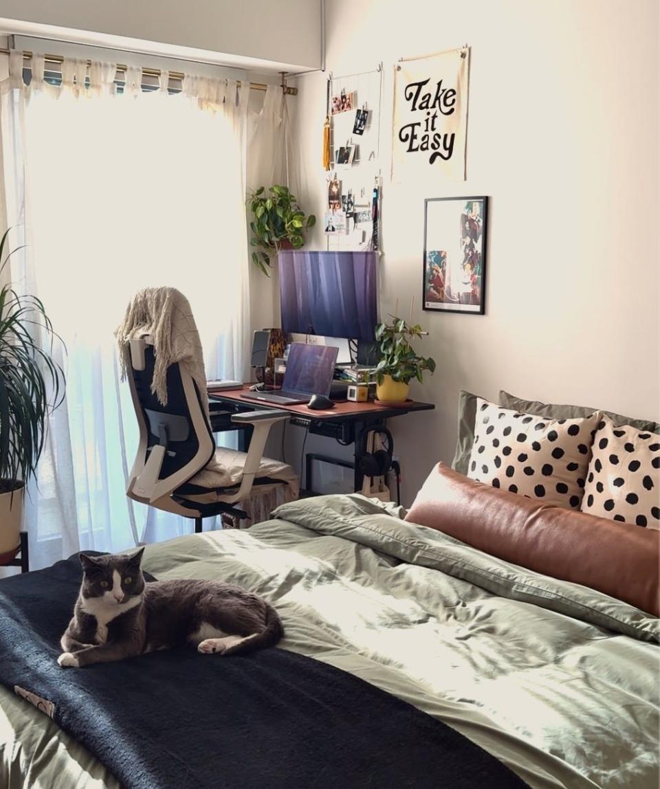 A bedroom with a desk in the far corner.