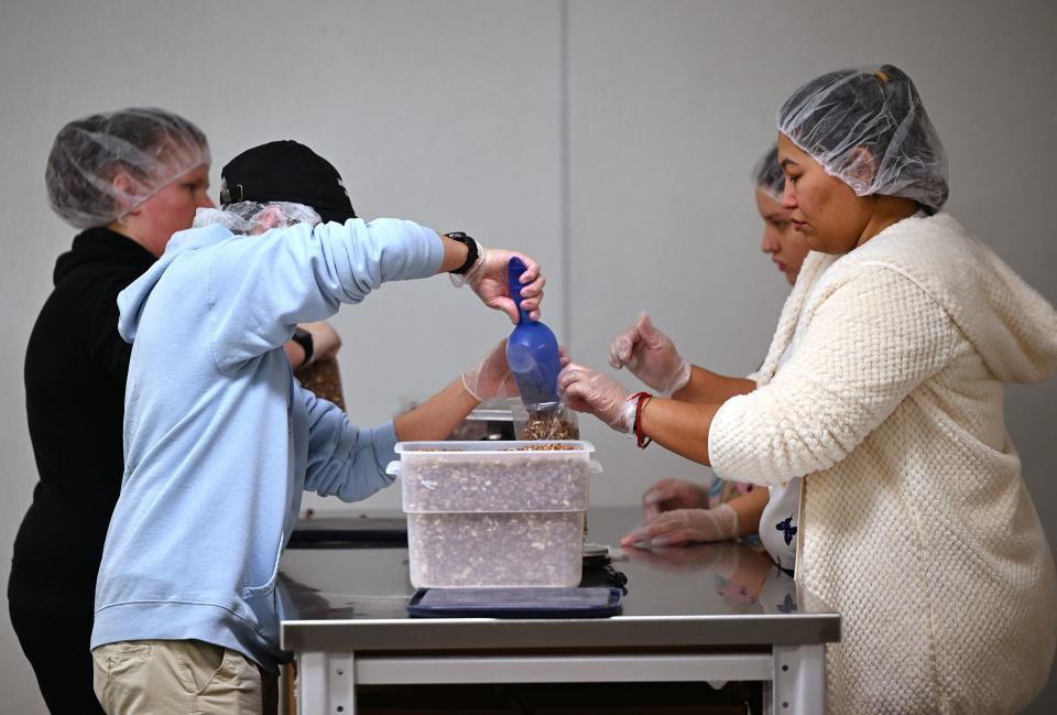 Volunteers assemble and fill bags of nuts at the Utah Food Bank and talk about the products and items they have for those that need them, at their South Salt Lake warehouses on Thursday, Dec. 28, 2023. | Scott G Winterton, Deseret News