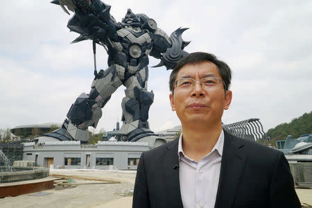 Chen Jianli, chief executive officer of Oriental Science Fiction Valley theme park, is pictured during an interview with Reuters in front of a giant robot statue at the park in Guiyang, Guizhou province, China November 16, 2017. REUTERS/Joseph Campbell/Files