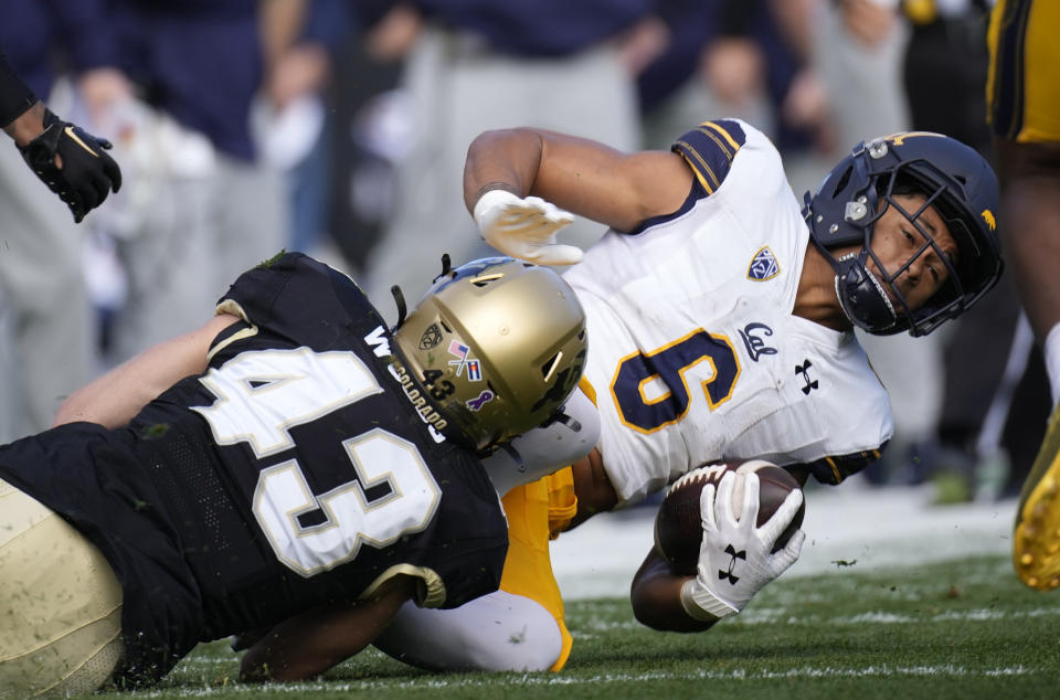 Colorado safety Trevor Woods pulls down California running back Jaydn Ott after a short gain in the first half of an NCAA college football game in Folsom Field Saturday, Oct. 15, 2022, in Boulder, Colo. (AP Photo/David Zalubowski)