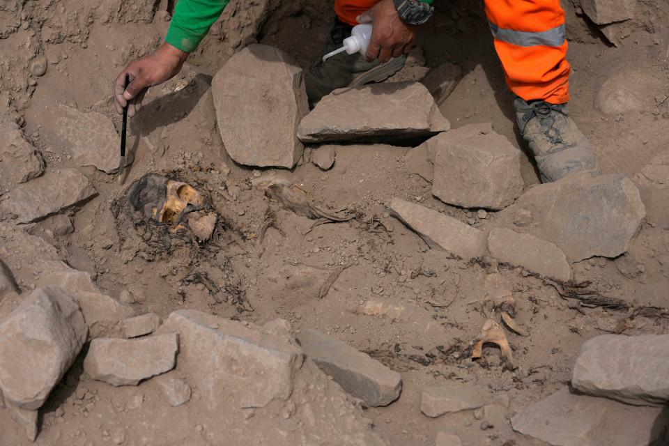 An archaeologist excavates a pre-Hispanic mummy that was discovered next to a training field for a Peruvian professional soccer team in the El Rimac neighborhood of Lima, Peru, Thursday, June 15, 2023. (AP Photo/Martin Mejia)