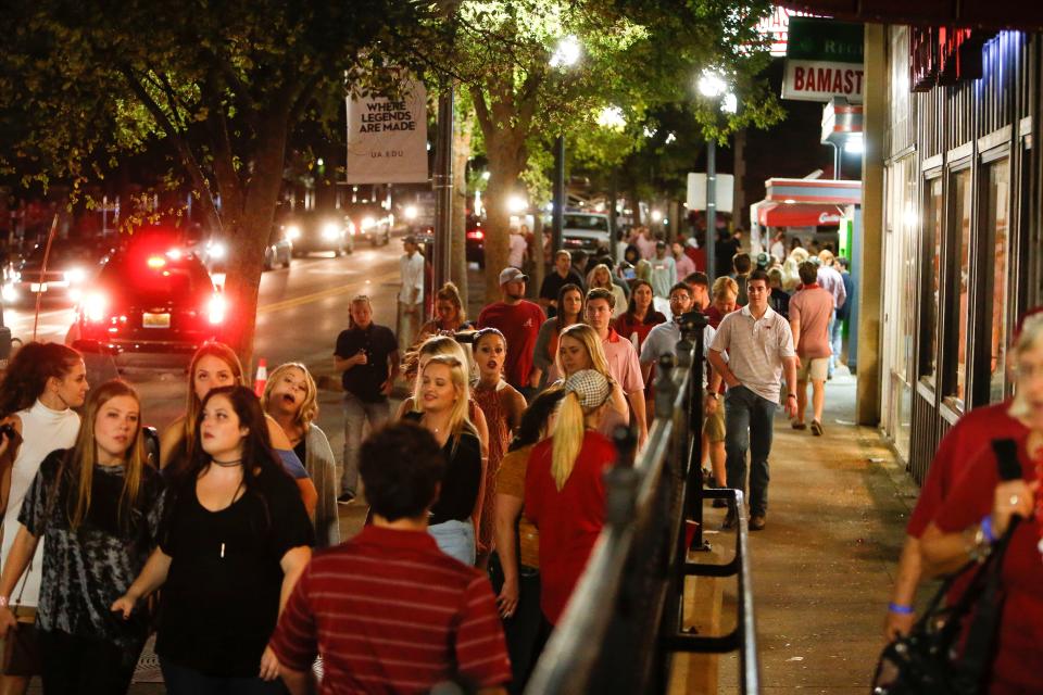 Pedestrian and vehicular traffic move along University Boulevard on the Strip, a business district with bars and restaurants near the University of Alabama campus, following the Alabama game with Tennessee on Oct. 21, 2017