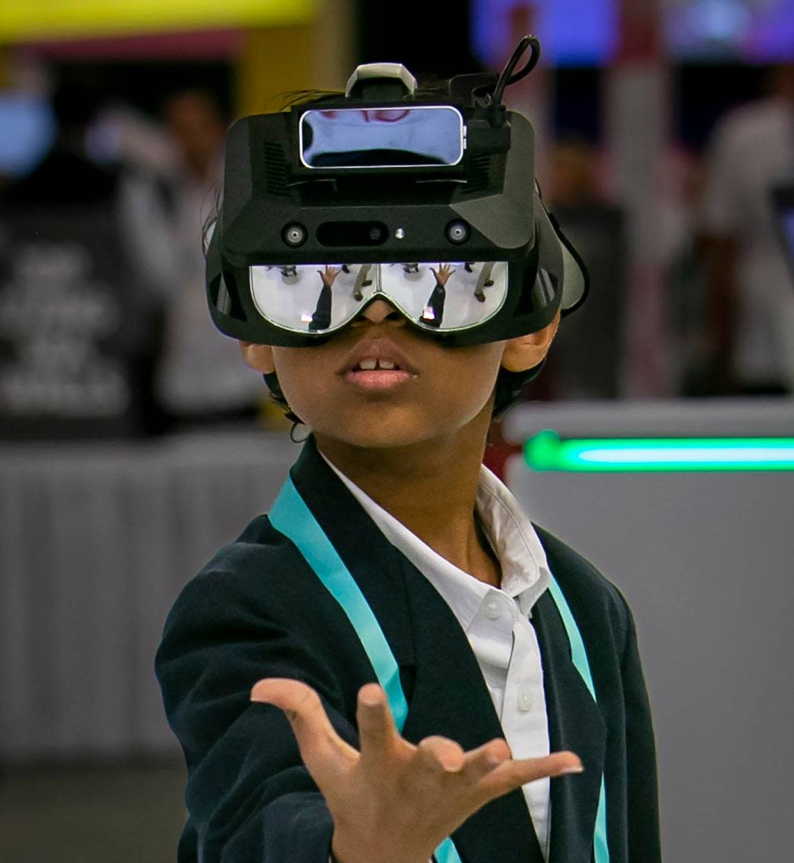 Kai Kihei, 9, plays with a virtual reality headset in the University of Miami booth at eMerge Americas in the Miami Beach Convention Center on April 20, 2023.