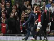 Manchester United's Nemanja Vidic leaves the field with a head injury during their English Premier League soccer match against Arsenal at Old Trafford in Manchester, northern England, November 10, 2013.