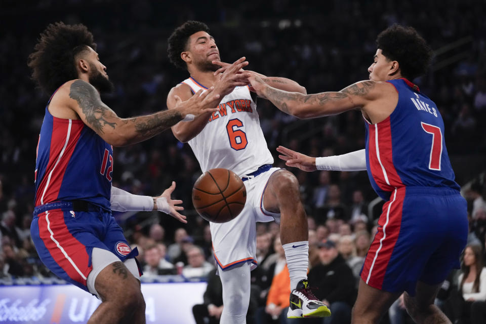 New York Knicks' Quentin Grimes, center, is defended by Detroit Pistons' Isaiah Livers, left, and Killian Hayes during the first half of an NBA basketball game, Thursday, Nov. 30, 2023, in New York. (AP Photo/Seth Wenig)