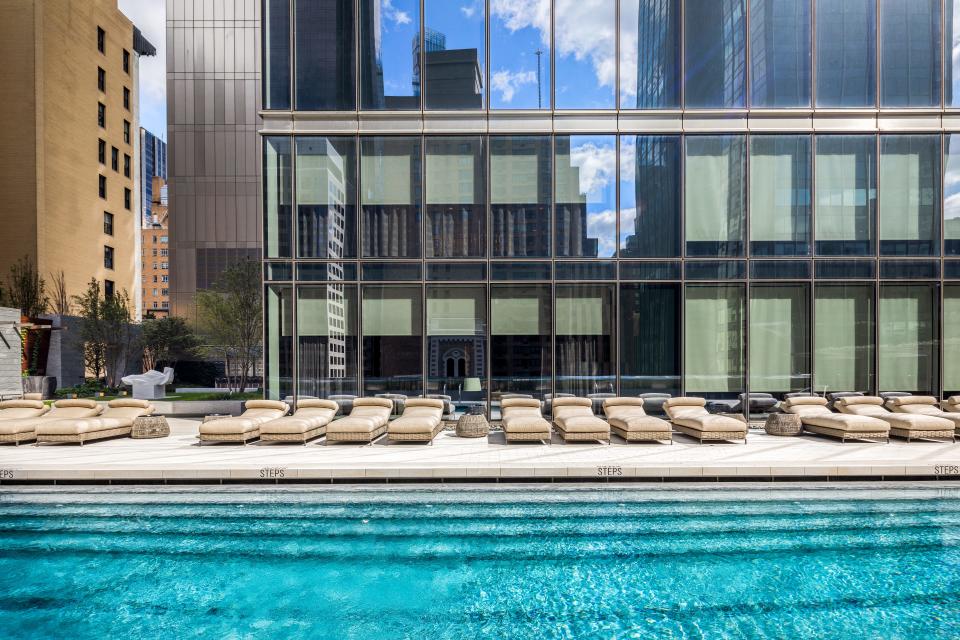 a pool and pool chairs on the 14th floor of luxury skyscraper Central Park Tower