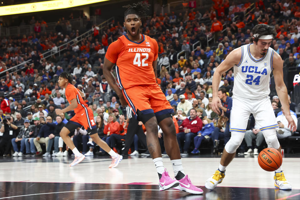 Illinois forward Dain Dainja (42) reacts after a play, next to UCLA guard Jaime Jaquez Jr. (24) during the first half of an NCAA college basketball game Friday, Nov. 18, 2022, in Las Vegas. (AP Photo/Chase Stevens)