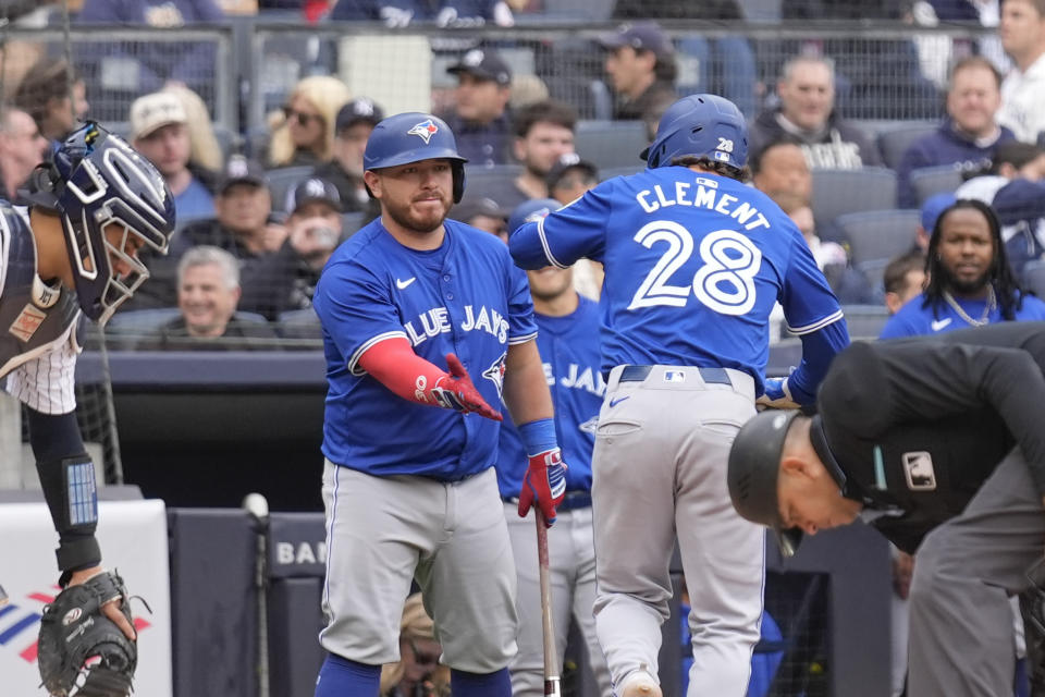 Toronto Blue Jays' Alejandro Kirk, left, greets Ernie Clement (28) after Clement hit a home run during the seventh inning of the baseball game against the New York Yankees at Yankee Stadium in New York, Friday, April 5, 2024.(AP Photo/Seth Wenig)