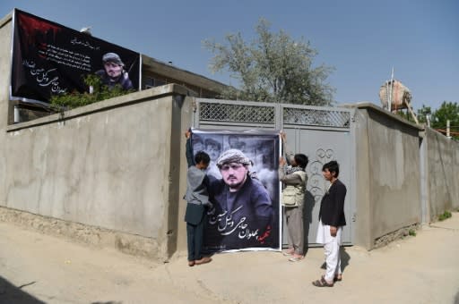 Relatives of Wakil Hussain Allahdad, 32, one of the 57 victims of a suicide attack on a voter registration centre in Kabul, hang up a banner bearing his picture outside his house in the Afghan capital on April 23, 2018