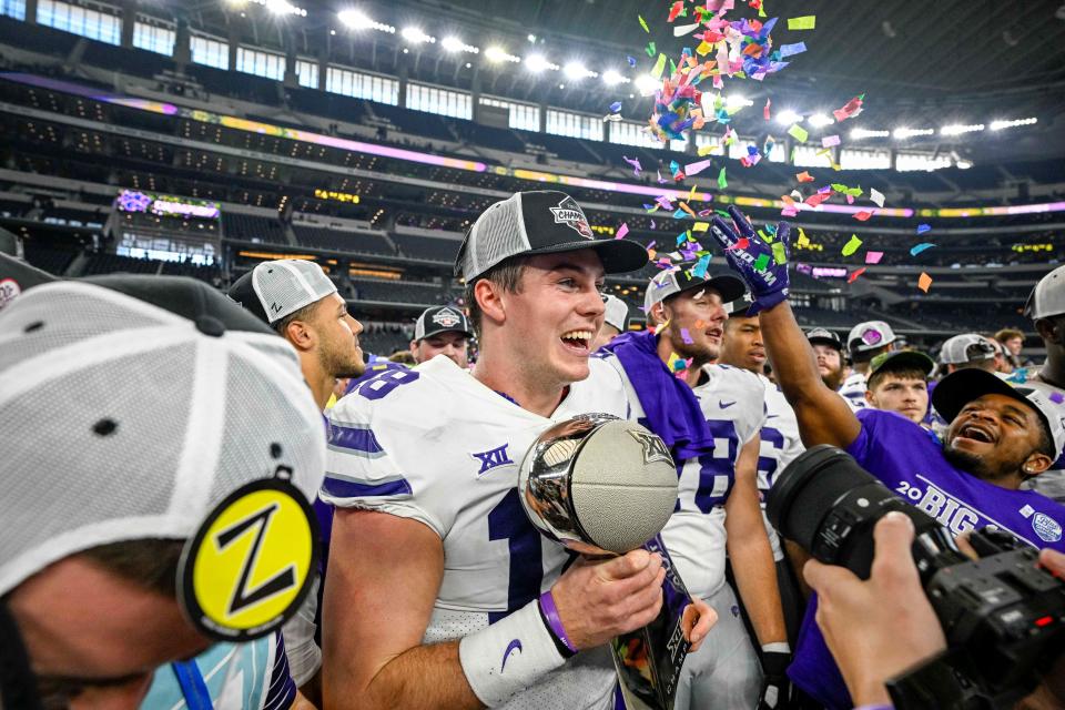 Kansas State quarterback Will Howard (18) clutches the Big 12 championship trophy after the Wildcats' 31-28 overtime victory over TCU on Saturday at AT&T Stadium in Arlington, Texas.