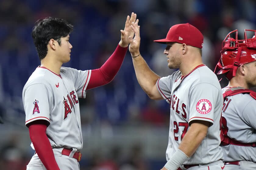 Angels pitcher Shohei Ohtani high-fives center fielder Mike Trout after beating the Marlins