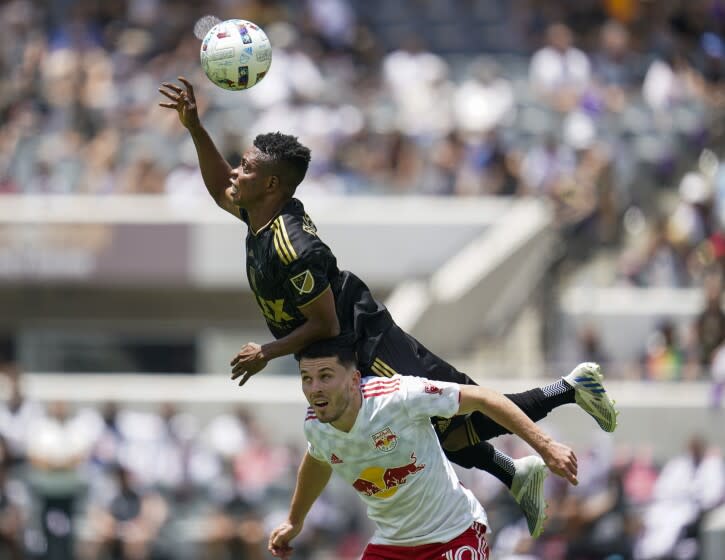 Los Angeles FC forward Latif Blessing (7) jumps over New York Red Bulls midfielder Lewis Morgan.