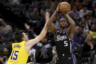 Sacramento Kings guard De'Aaron Fox (5) shoots against Los Angeles Lakers guard Austin Reaves (15) during the second half of an NBA basketball game in Sacramento, Calif, Wednesday, March 13, 2024. (AP Photo/Jed Jacobsohn)