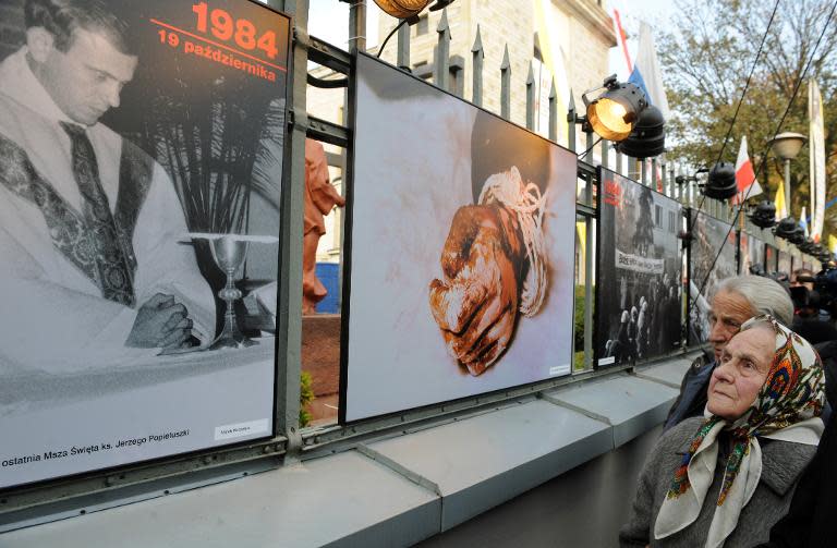 Marianna Popieluszko, mother of late Catholic priest Jerzy Popieluszko looking at a pictures in Warsaw of her son. The photo on the right shows his hand after his bound remains were found in a waterway in 1984