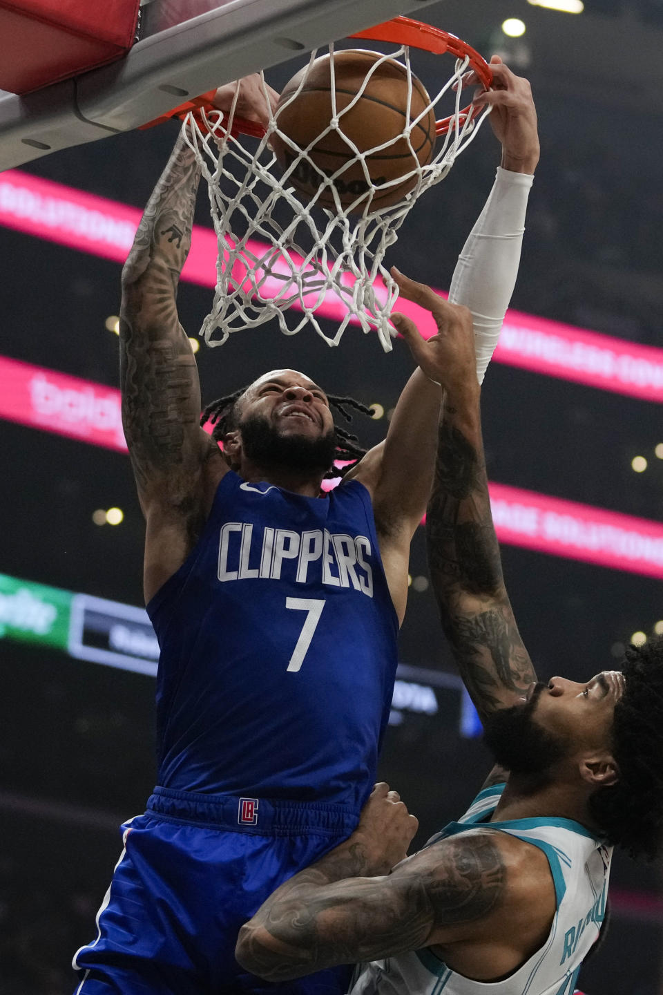 Los Angeles Clippers guard Amir Coffey (7) dunks against Charlotte Hornets center Nick Richards, right, during the first half of an NBA basketball game in Los Angeles, Tuesday, Dec. 26, 2023. (AP Photo/Ashley Landis)