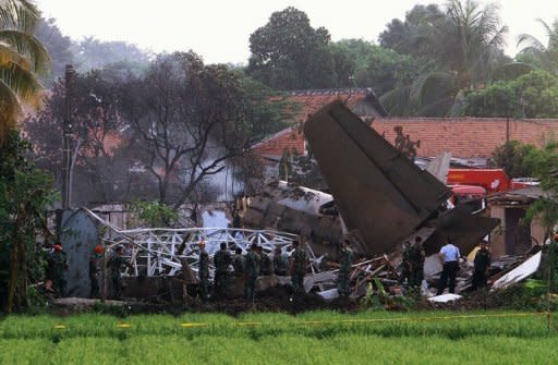 Emergency personnel look through the rubble after an Indonesian military Fokker-27 aircraft crashed in Jakarta on June 21. The number of people killed when the jet crashed into a housing complex has risen to 11, an air force spokesman said Friday