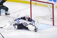 The puck shot by Minnesota Wild's Mats Zuccarello sails past Winnipeg Jets goalie Connor Hellebuyck for a goal during the first period of an NHL hockey game Tuesday, Oct. 19, 2021, in St. Paul, Minn. (AP Photo/Jim Mone)