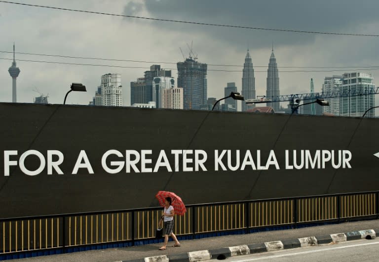 A Malaysian woman walks past the construction site of the 1 Malaysia Development Berhad (1MDB) flagship Tun Razak Exchange in Kuala Lumpur on July 3, 2015