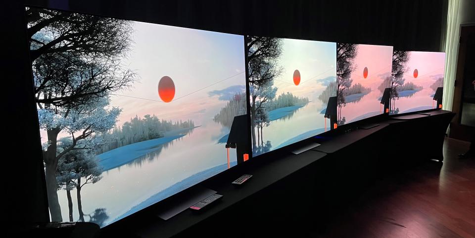 LG G3 OLED TV on stand with other TVs showing landscape image