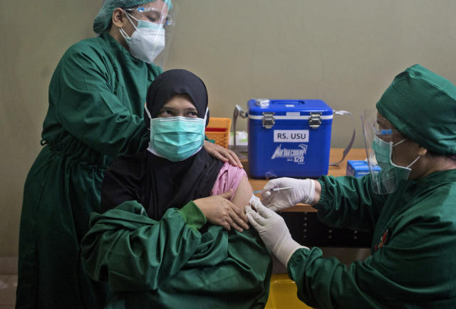 FILE - In this Wednesday, Jan. 20, 2021 file photo, Dr. Lili Rahmawaty, right, gives a shot of COVID-19 vaccine to a colleague at North Sumatra University Hospital in Medan, North Sumatra, Indonesia. The choices are limited for Indonesia, the world's fourth most populous country, and many other low- and middle-income countries clobbered by COVID. Vaccine deployment globally has been dominated by rich countries, which have snapped up 5.4 billion of the 7.8 billion doses purchased worldwide, according to Duke University. (AP Photo/Binsar Bakkara)