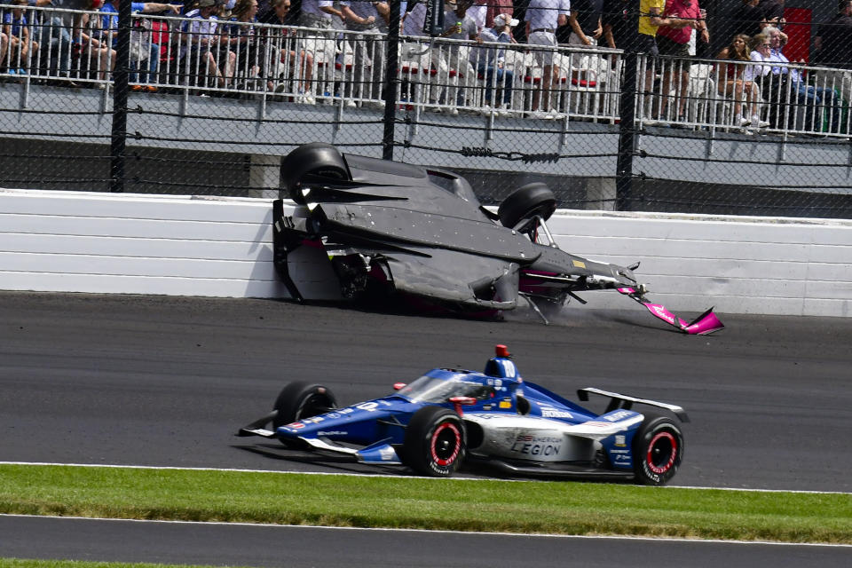 The car driven by Kyle Kirkwood, top, flips over after a crash in the second turn during the Indianapolis 500 auto race at Indianapolis Motor Speedway in Indianapolis, Sunday, May 28, 2023. (AP Photo/John Maxwell)