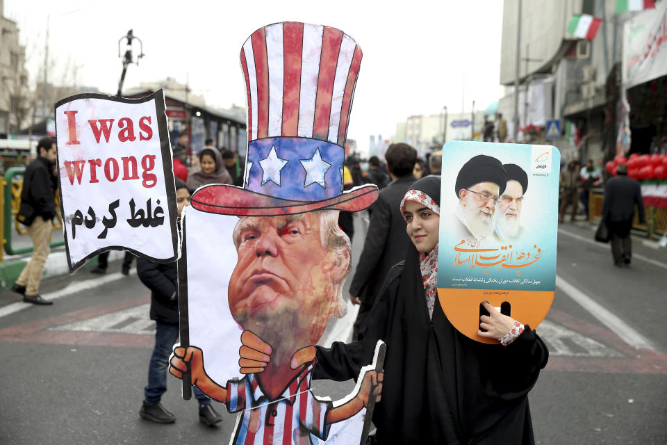 FILE - In a Feb. 11, 2019 file photo, an Iranian woman holds an effigy of US president Donald Trump, during a rally marking the 40th anniversary of the 1979 Islamic Revolution, in Tehran, Iran. On Monday, June 17, 2019, Iran said it will break the uranium stockpile limit set by Tehran's nuclear deal with world powers in the next 10 days. (AP Photo/Ebrahim Noroozi, File)