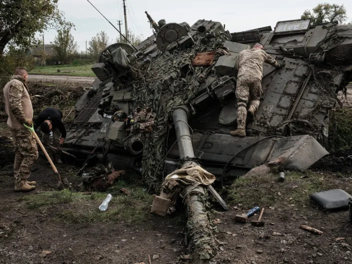 Ukrainian soldiers scavenge an abandoned Russian T-90A tank in Kyrylivka, in the recently retaken area near Kharkiv, on September 30, 2022.