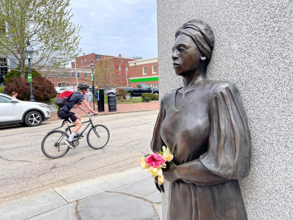 A biker rides down State Street and passes the entrance area of African Burying Ground in Portsmouth on a beautiful Thursday afternoon. The annual ceremony will take place at 11 a.m. on Wednesday, June 19, 2024.