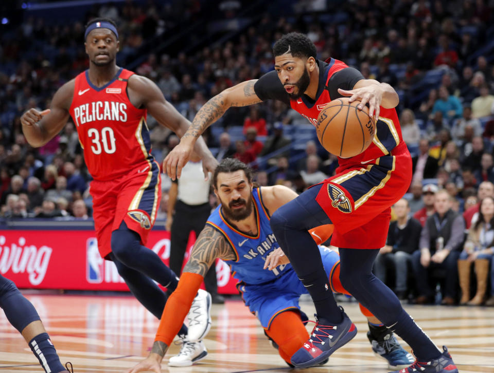 New Orleans Pelicans forward Anthony Davis (23) battles for control of the ball against Oklahoma City Thunder center Steven Adams (12) in the first half of an NBA basketball game in New Orleans, Wednesday, Dec. 12, 2018. (AP Photo/Gerald Herbert)