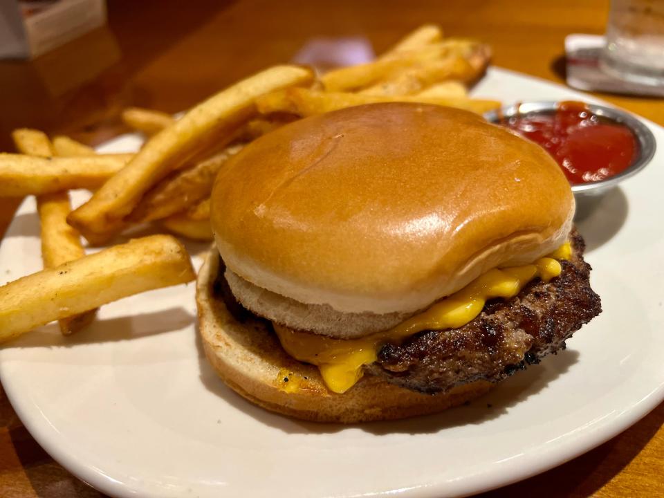 Cheeseburger with fries and a container of ketchup at Outback Steakhouse