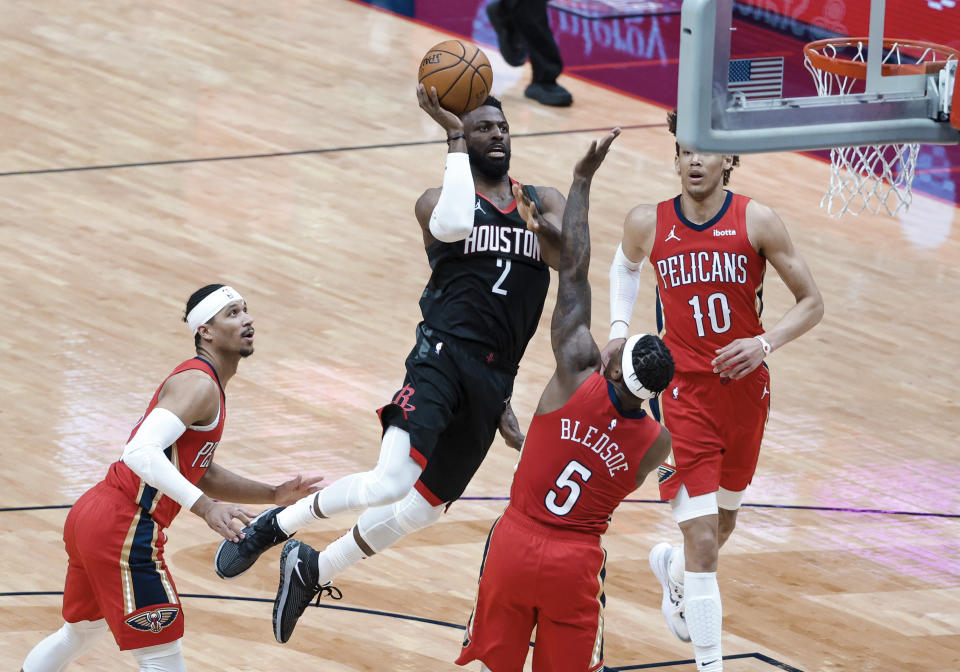 Houston Rockets guard David Nwaba (2) shoots between New Orleans Pelicans guard Eric Bledsoe (5), guard Josh Hart (3) and center Jaxson Hayes (10) during the first quarter of an NBA basketball game in New Orleans, Saturday, Jan. 30, 2021. (AP Photo/Derick Hingle)