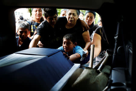 Relatives mourn near the coffin of police officer Juan Jimenez, who was a victim of the earthquake that struck the southern coast of Mexico late on Thursday, during his burial in Juchitan, Mexico, September 10, 2017. REUTERS/Carlos Jasso