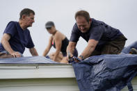 Bob Primeaux, right, works with his son Robbie in the aftermath of Hurricane Laura on a roof that was damaged on Friday, Aug. 28, 2020, in Homewood, La. (AP Photo/Gerald Herbert)