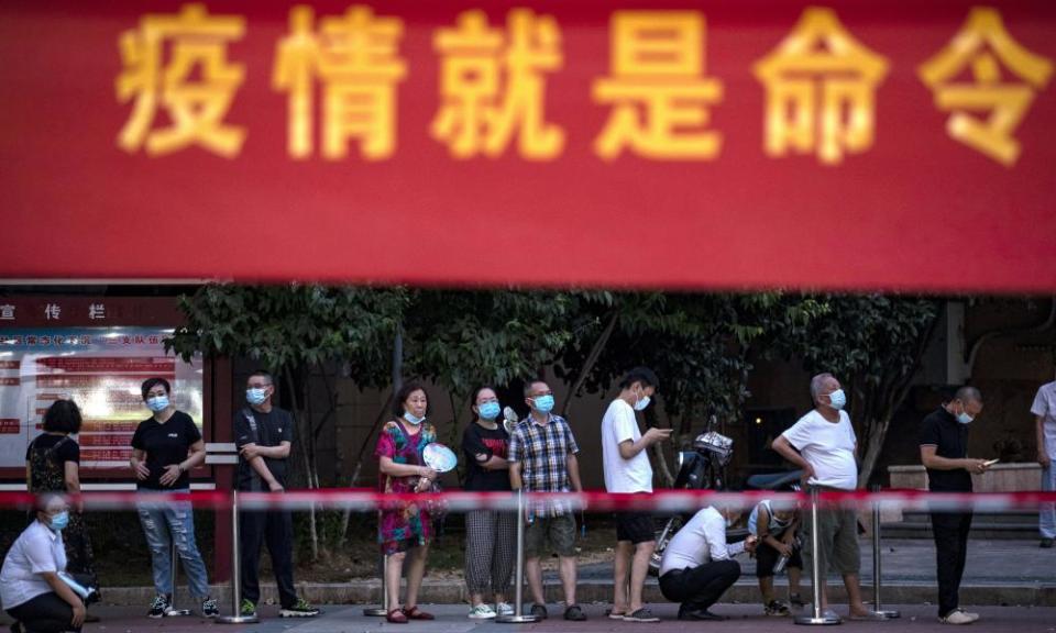 Residents line up for Covid-19 tests near a banner with the words “Epidemic is the Order” in Wuhan in central China’s Hubei province