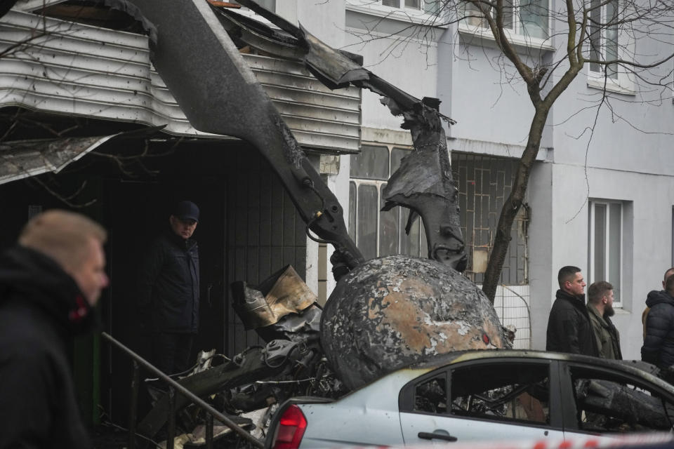 The propeller of helicopter is seen near apartments at the scene where a helicopter crashed on civil infrastructure in Brovary, in the outskirts of Kyiv, Ukraine, Wednesday, Jan. 18, 2023. The chief of Ukraine's National Police says a helicopter crash in a Kyiv suburb has killed 16 people, including Ukraine's interior minister and two children. He said nine of those killed were aboard the emergency services helicopter. (AP Photo/Efrem Lukatsky)