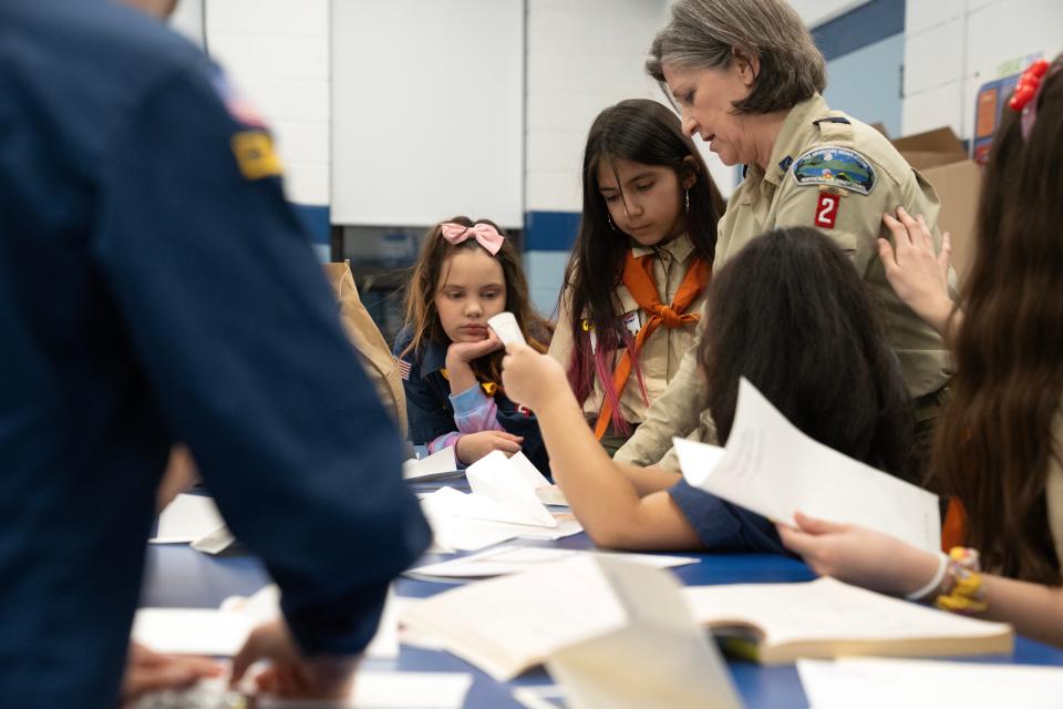Mar 20, 2024; Prospect Park, NJ, USA; (From left) Addyson Borda, Sophia Rodríguez and Cub Master Lisa Esteves make paper airplanes during a Prospect Park Cub Scout Pack 2 meeting at Prospect Park Elementary School.