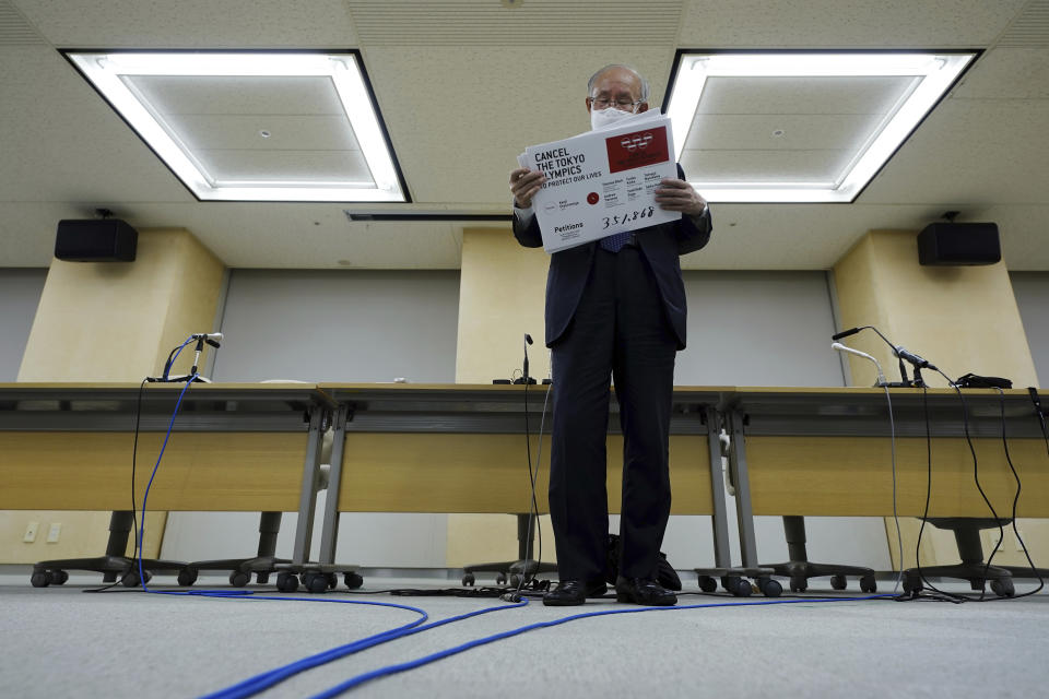 Lawyer Kenji Utsunomiya, a representative of an anti-Olympics group, arranges boards showing the current figure of online petition during a press conference after submitting a petition to the Tokyo government calling for the cancellation of the Tokyo 2020 Olympics and Paralympics. An online petition calling for the Tokyo Olympics to be cancelled has been submitted to the Tokyo government with over 350,000 signatures on Friday morning. The rollout of the petition comes with Tokyo, Osaka and several other areas under a state of emergency with coronavirus infections rising - particularly new variants. (AP Photo/Eugene Hoshiko)