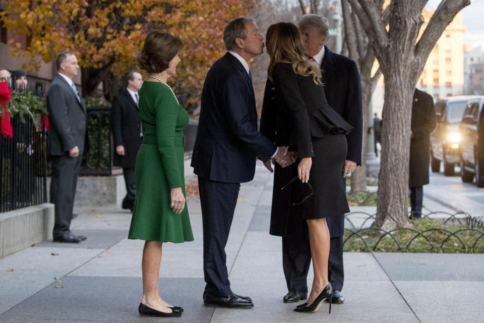 President Donald Trump and first lady Melania Trump are greeted by former President George Bush and former first lady Laura Bush outside the Blair House across the street from the White House in Washington, Tuesday, Dec. 4, 2018. (AP Photo/Andrew Harnik)