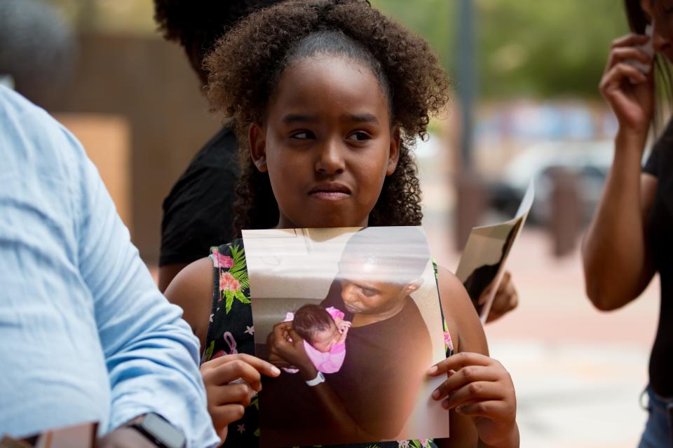 Naiya Thompson, a daughter of Fort Bliss veteran Michael Charles Thompson, holds photos of her father at a news conference outside the El Paso County Courthouse on Thursday, June 27, 2024. Her father died on June 27, 2022, in police custody as he was seeking help in a mental health crisis.