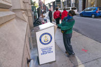 FILE - In this Oct. 14, 2020, file photo, Eva Abodoadji drops off a mail ballot into an official ballot drop box as voters wait in line at City Hall as in-person early voting begins for the general election in Rhode Island in Providence, R.I. As it has for more than 170 years, The Associated Press will count the vote and report the results of presidential, congressional and state elections quickly, accurately and without fear or favor on Nov. 3 and beyond. (AP Photo/David Goldman)