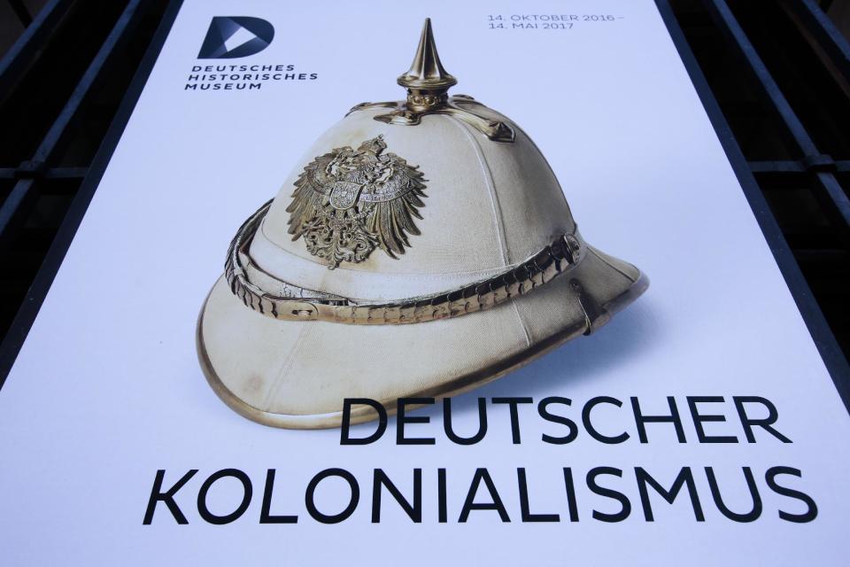 A poster for the exhibition 'German Colonialism' with a historic German spiked helmet displayed outside the German Historic Museum in Berlin, Friday, Jan. 6, 2017. Germany says Friday Jan. 6, 2017 it could make further payments to Namibia for the killing of 65,000 tribes people by German colonial troops during the early 20th century. Foreign Ministry spokesman Martin Schaefer says the two-year talks with Namibia’s government “aren’t easy because it’s a difficult topic.” His comments come a day after representatives of the Herero and Nama tribes filed a class action complaint against the German government in the United States, seeking reparations and a place at the negotiating table. (AP Photo/Markus Schreiber)