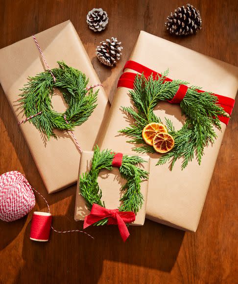 wrapped presents with greenery red ribbon and dried citrus decorations