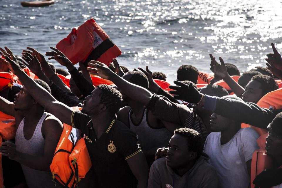 Migrants reach out for floatation vests waiting to board the MV Aquarius, as 193 people and two corpses are recovered Friday Jan. 13, 2017, from international waters in the Mediterranean Sea about 22 miles (35 Km) north of Sabrata, Libya. The MV Aquarius search and rescue vessel operated by MSF and SOS Mediterranee picked up 183 male and 10 female migrants, thought to have originated from African countries including Nigeria, Gambia and Senegal. The migrants are expected to disembark in Italy. (AP Photo/Sima Diab)